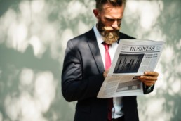Guy holding newspaper with Business headline