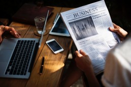 Table meeting with laptop, phone and newspaper